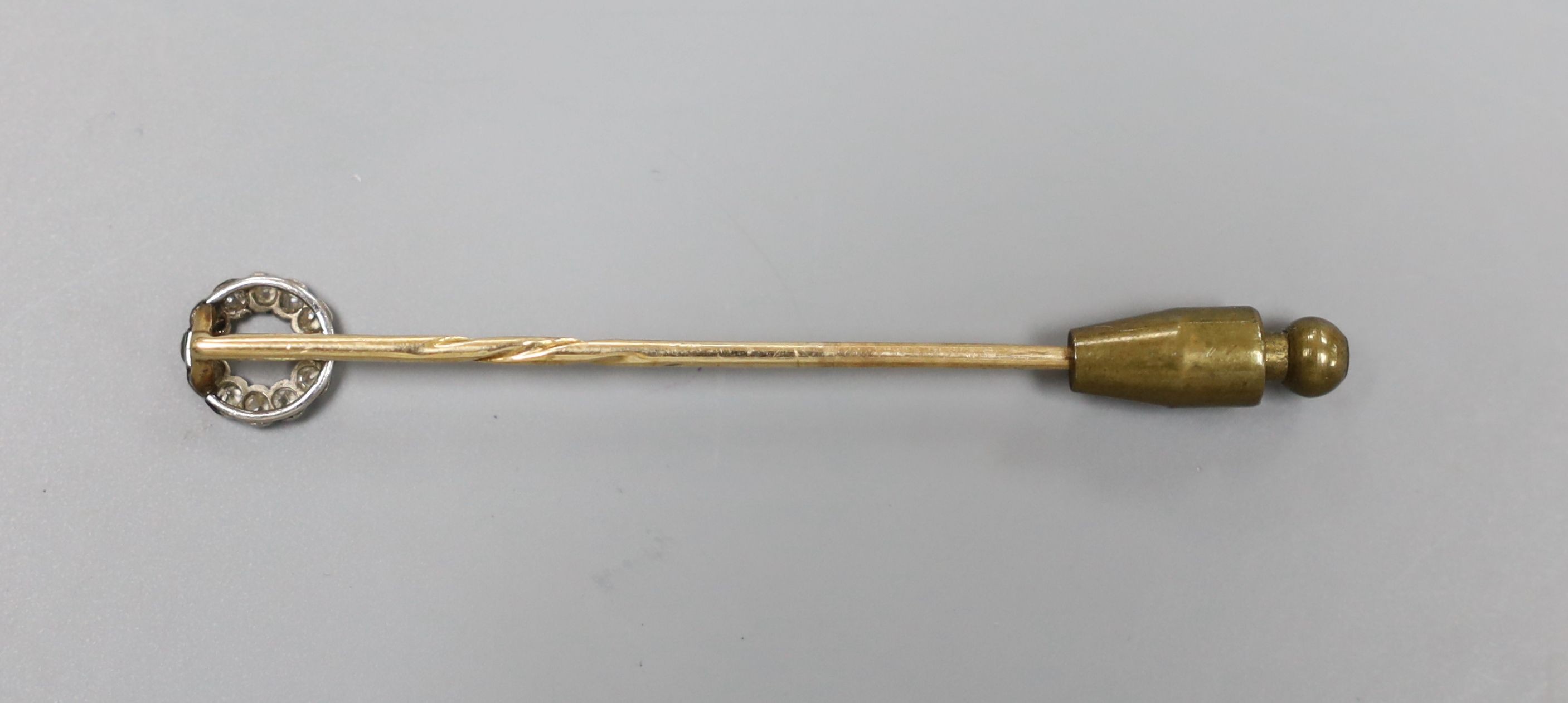 An Edwardian yellow metal and diamond cluster set stick pin, 58mm, gross 1.4 grams.